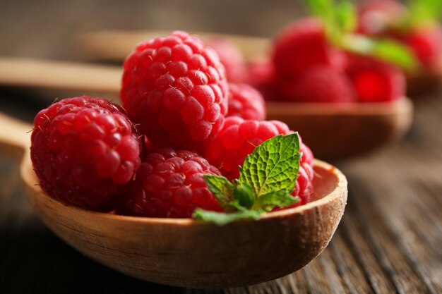 Framboises rouges fraîches en cuillères sur table en bois libre