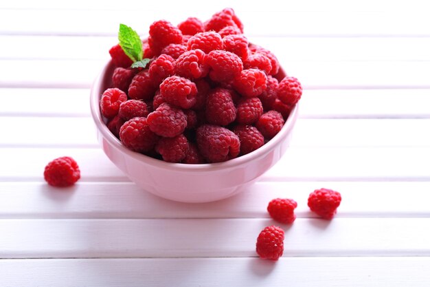 Framboises sucrées mûres dans un bol sur la table libre