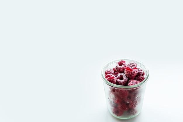 Framboises surgelées dans un verre avec givre.