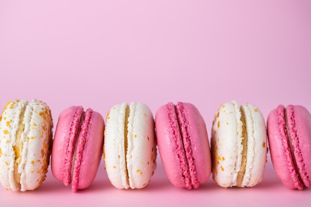 Français délicieux macarons roses et blancs de différentes saveurs