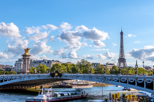 Photo la france. journée d'été ensoleillée à paris. bateau de plaisance sous le pont d'alexandre iii sur la seine. tour eiffel