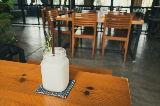 Frappe d'eau de noix de coco fraîche avec feuille de romarin sur table de restaurant