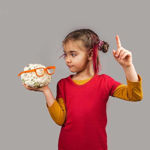 Freakish kid détient des fruits et légumes de mauvaise couleur déformés, concept de déchets alimentaires