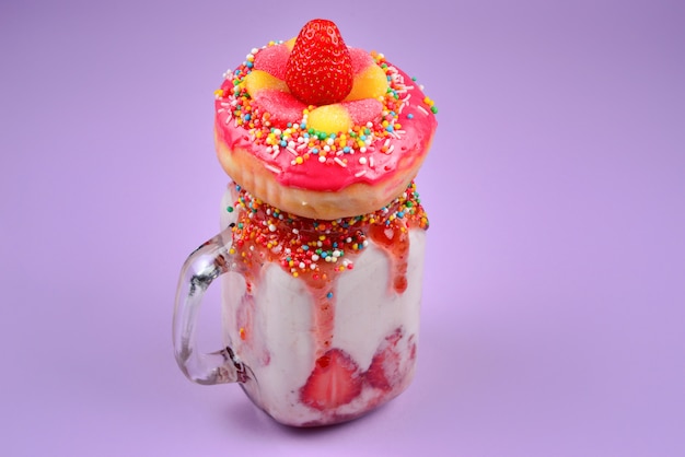 Freakshake. Milkshake extrême avec fraise, bonbons à la gelée, beignet.