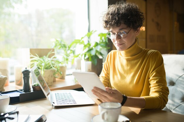 Freelance aux cheveux bouclés analysant les informations en ligne