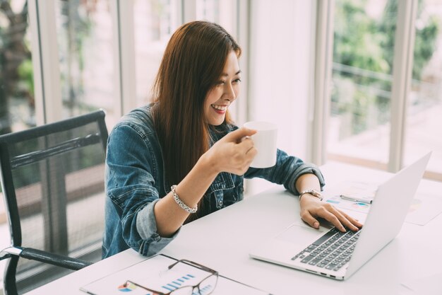 Freelancer femme buvant un café avec un ordinateur portable numérique