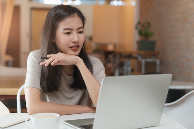 Freelancer fille asiatique travaillant dans un espace de travail partagé.