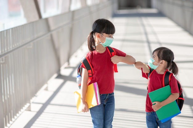 Un frère asiatique avec un masque facial retourne à l'école après la quarantaine et le verrouillage de covid-19