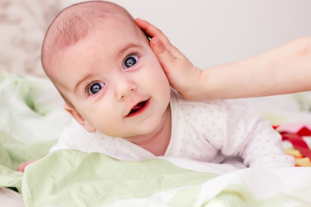 un frère doux touche la joue du bébé. Une peau saine