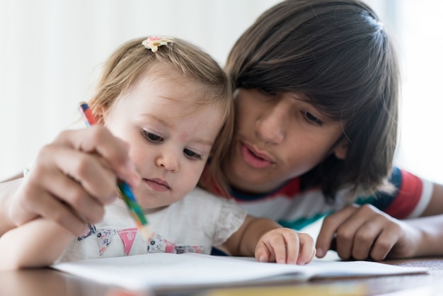 Frère jouant et dessinant avec sa petite soeur