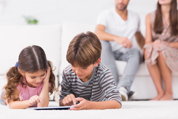 Frère et soeur à l&#39;aide de tablet pc ensemble sur le sol