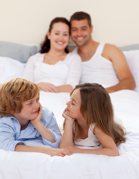 Frère et soeur au lit avec ses parents