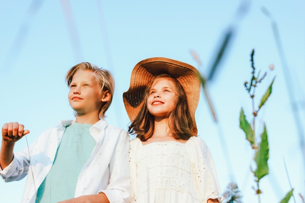 frère et soeur dans l'herbe du ciel bleu