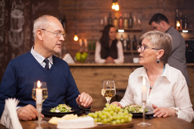 Frère et sœur dans la soixantaine profitant de leur temps ensemble tout en dînant dans un restaurant vintage. Heureux homme et femme.