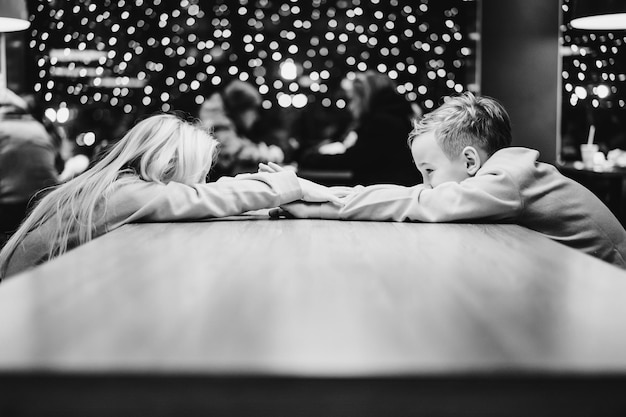 Frère Et Soeur Sur Le Fond D'une Guirlande Festive, Lumières Du Nouvel An, Enfants.