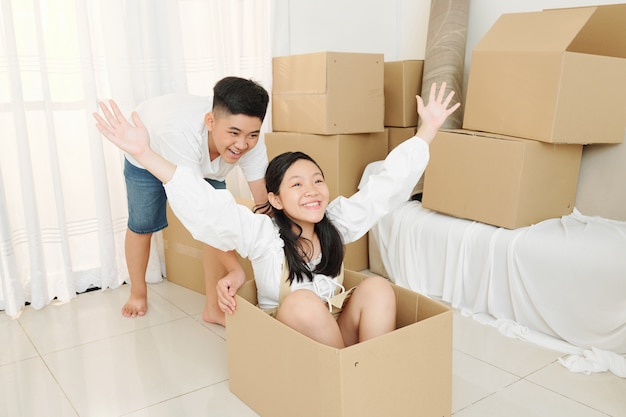 Frère et sœur jouant avec une boîte en carton