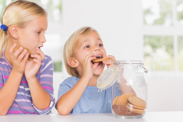 Frère et soeur mangeant des biscuits