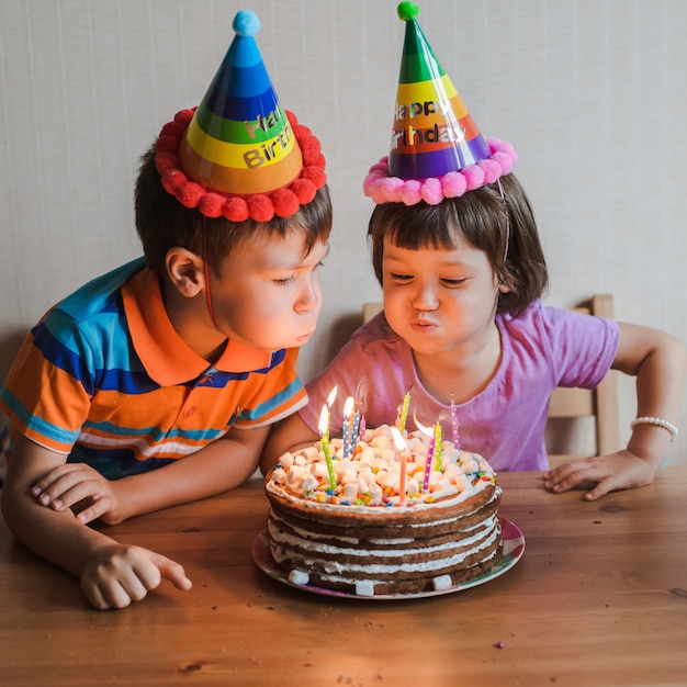 Frère Et Sœur Mangeant Un Gâteau D'anniversaire Avec Des Bougies Qui Soufflent Et S'étreignent.