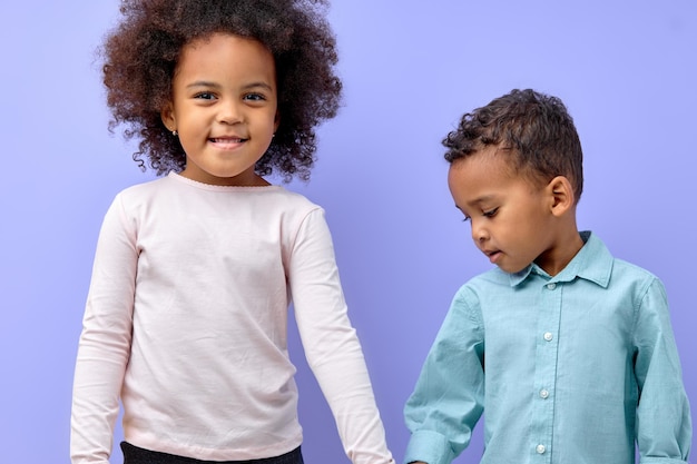 Frère et sœur posant ensemble isolé sur violet heureux frère souriant s'amusant excité et c