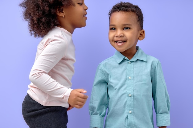 Frère et soeur posant ensemble isolés sur violet, heureux frère souriant