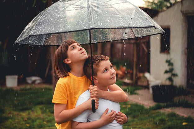 Frère et soeur profitant de la pluie