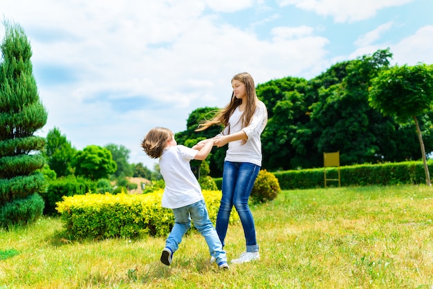 Frère et soeur s'amusant à jouer dans le parc