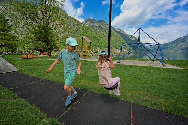 Frère et sœur se balançant dans une aire de jeux à Hallstatt Autriche