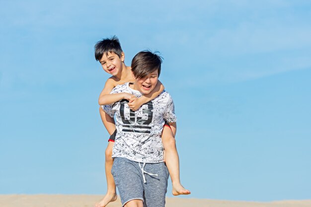 Frères jouant dans les dunes