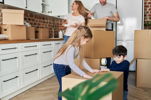 Les frères et sœurs aident à emballer les boîtes de carton pour le déménagement