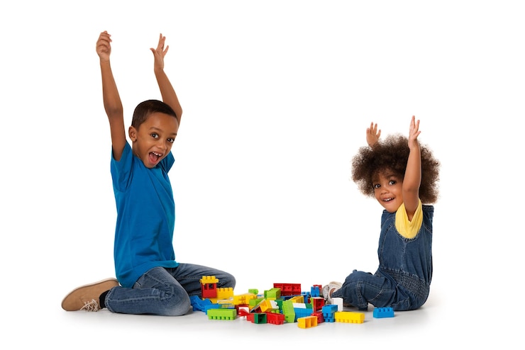 Photo des frères et sœurs jouant avec des blocs de jouets sur un fond blanc
