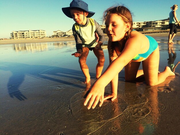 Photo des frères et sœurs jouant à la plage.