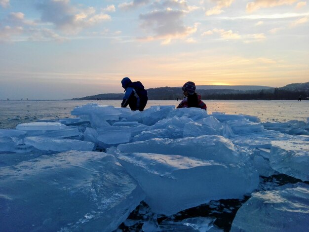 Photo des frères et sœurs par formation de glace contre le ciel au coucher du soleil