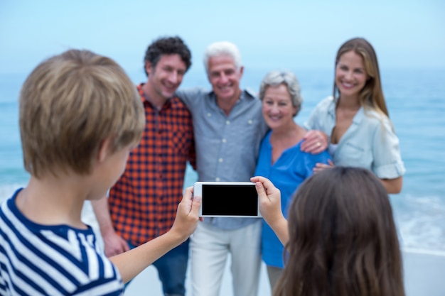 Photo frères et soeurs photographiant la famille avec un smartphone