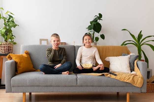 Photo frères et sœurs regardant la télévision ensemble