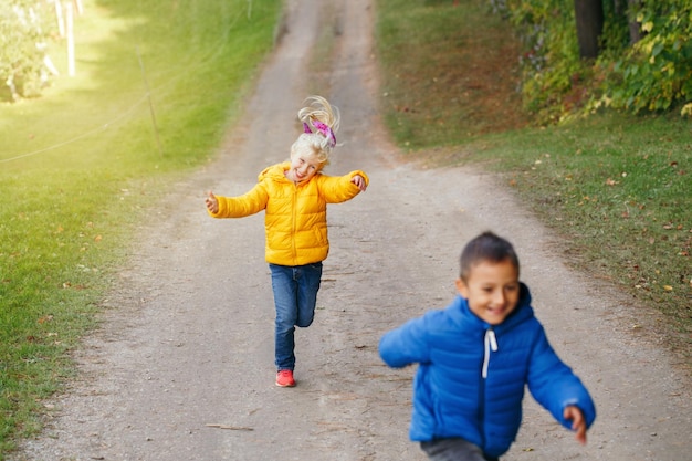 Des frères et sœurs souriants courent sur le sentier.