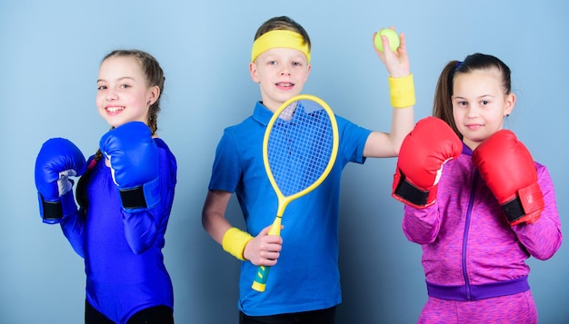 Frères et sœurs sportifs Façons d'aider les enfants à trouver le sport qu'ils aiment Amis prêts pour l'entraînement sportif L'enfant peut exceller dans un sport complètement différent Filles enfants avec équipement de sport de boxe et garçon joueur de tennis