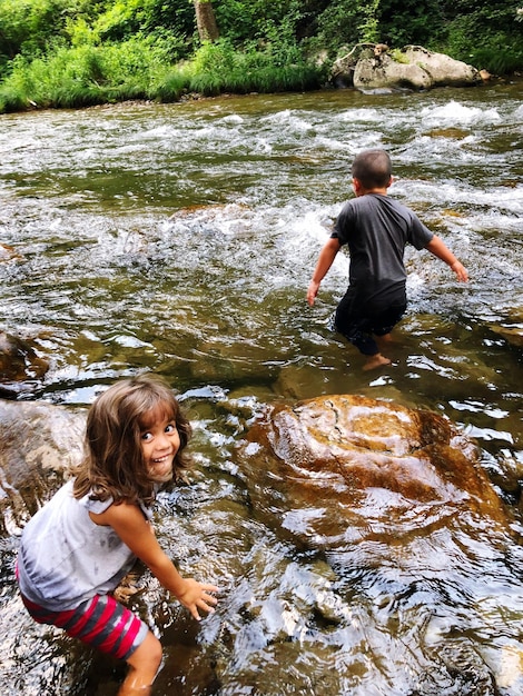 Photo des frères et sœurs en train de patauger dans la rivière