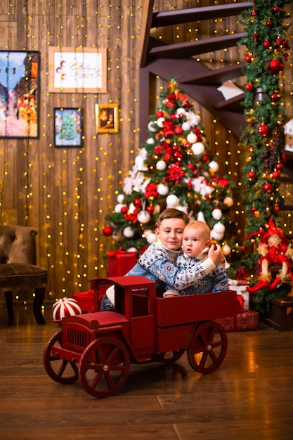 Les frères sont assis sous le sapin de Noël en attendant les cadeaux du Nouvel An39