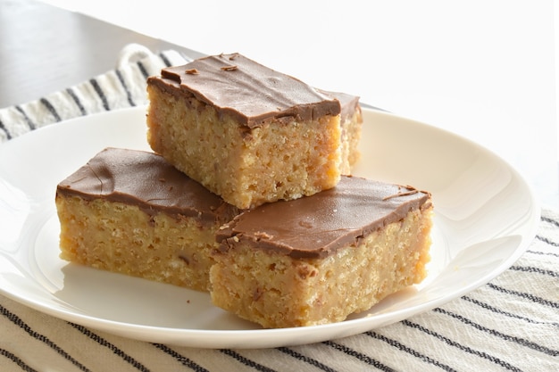 Friandises croustillantes de riz au caramel au chocolat sur une plaque blanche