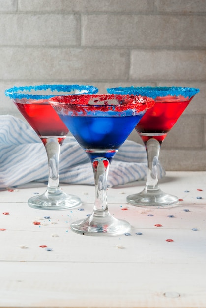 Friandises pour le jour de l'indépendance le 4 juillet Cocktails alcoolisés faits maison punch aux couleurs traditionnelles - rouge bleu blanc avec de la glace sur la table de la cuisine à domicile