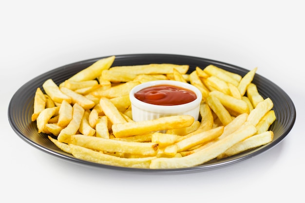 Frites sur l'assiette avec du ketchup, fond blanc, tournage en studio.