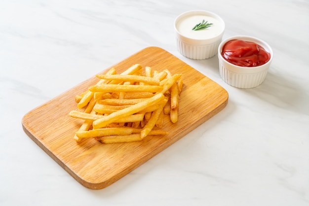 Frites ou chips de pomme de terre avec crème sure et ketchup