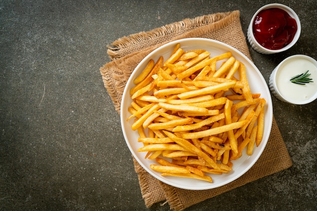 Frites ou chips de pomme de terre avec crème sure et ketchup