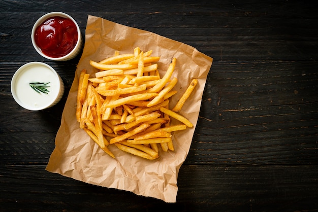 Frites ou chips de pomme de terre avec crème sure et ketchup