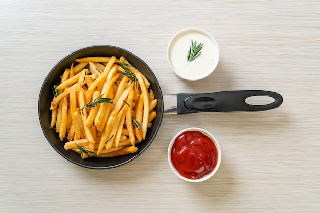 Frites ou chips de pomme de terre avec crème sure et ketchup