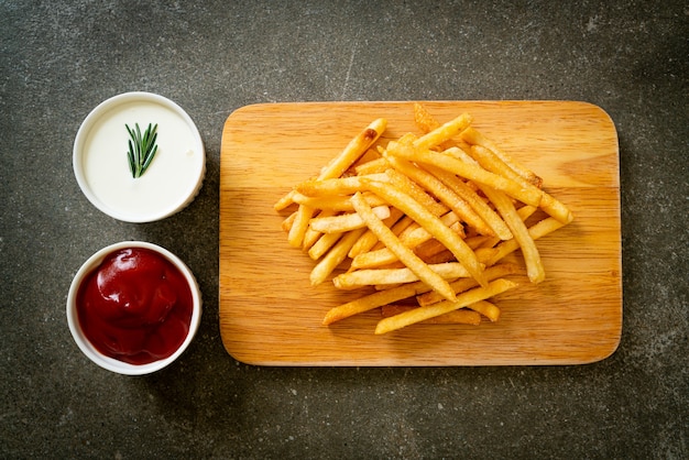 Frites ou chips de pomme de terre avec crème sure et ketchup