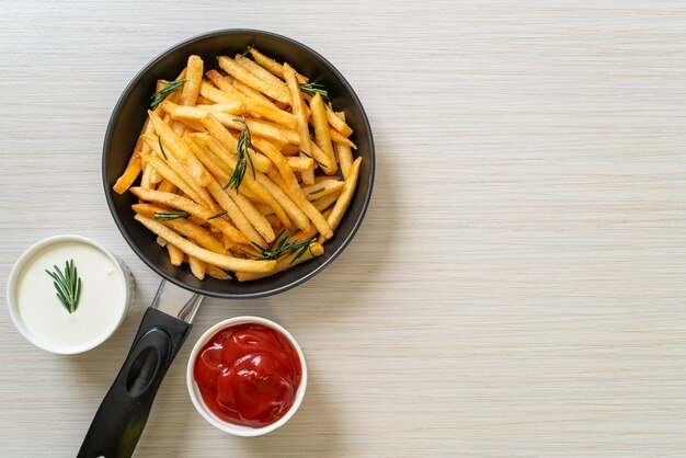 Frites ou chips de pomme de terre avec crème sure et ketchup