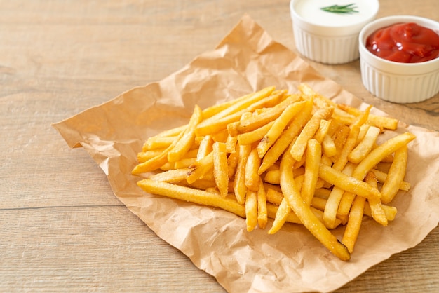 Frites ou chips de pomme de terre avec crème sure et ketchup