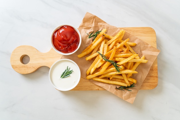 Frites ou chips de pomme de terre avec crème sure et ketchup