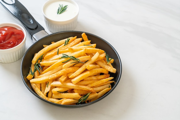 Frites ou chips de pomme de terre avec crème sure et ketchup